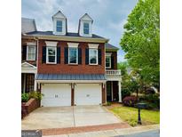 Charming red brick townhome featuring a two-car garage and dormer windows at 11945 Dancliff Trce, Alpharetta, GA 30009