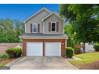Charming two-story home with a brick and vinyl exterior, two-car garage, and well-maintained landscaping at 164 Stoneforest Dr, Woodstock, GA 30189
