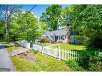 Charming home featuring a white picket fence, lush green lawn, and mature trees at 527 W Church St, Villa Rica, GA 30180