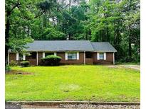 Charming single-story brick home with a well-maintained front yard and a backdrop of lush trees at 105 Meadowbrook Ct, Fayetteville, GA 30215
