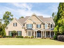 Charming two-story home featuring a stone and brick facade, manicured lawn, and welcoming front entrance at 4090 Cooks Farm Nw Dr, Kennesaw, GA 30152