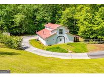 Charming two-story home with a red roof, set amidst a lush green lawn and surrounding trees at 3258 South Mckoy Rd, Villa Rica, GA 30180