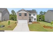 Charming two-story home with a brick and siding exterior, two-car garage, and well-manicured front yard at 178 Aster, Locust Grove, GA 30248