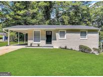 Charming single-story home with a well-manicured lawn and a welcoming black front door at 438 Fedora Nw Way, Atlanta, GA 30331