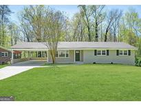 Charming single-story home featuring a spacious front lawn and a convenient covered carport at 1889 Silver Creek Dr, Austell, GA 30168