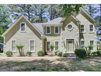 Charming front exterior features light stucco, multi-pane windows, and a meticulously landscaped front yard at 121 Tamerlane, Peachtree City, GA 30269