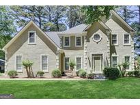 Traditional two-story home with stucco exterior, well-manicured lawn and mature trees at 121 Tamerlane, Peachtree City, GA 30269