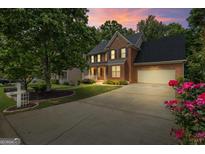 A charming two-story brick home with a well-manicured lawn and inviting front porch at 126 Ardenlee Dr, Peachtree City, GA 30269