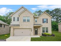 Charming two-story home with a brick facade, attached garage, and well-maintained front lawn at 116 Cabin Way, Hampton, GA 30228