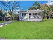 Charming painted brick home featuring a covered front porch and a well-manicured lawn at 4162 Mercer Rd, Decatur, GA 30035