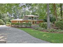 Traditional two-story home featuring brick facade, lush landscaping, and a curved driveway at 104 Whisper Trce, Peachtree City, GA 30269