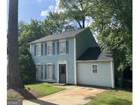 Charming two-story home with light blue siding, black shutters, and a well-manicured lawn at 4981 Millstone Walk, Stone Mountain, GA 30088