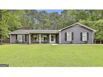 Charming single-story home with a well-manicured lawn, covered porch, and gray siding at 125 Wendell Ct, Fayetteville, GA 30215