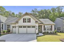 Charming single-story home with a three-car garage, tidy lawn, and manicured landscaping at 430 Silverbell Ct, Peachtree City, GA 30269