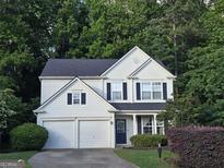 Charming two-story home with a well-manicured lawn and a two-car garage nestled among lush trees at 2022 Maple Ridge, Acworth, GA 30101