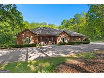 Stunning brick home with a lush, tree-lined landscape and private driveway at 110 Woodland Rd, Fayetteville, GA 30214