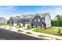 Modern townhomes with brick exteriors, attached garages, and well-maintained lawns and landscaping at 240 Epping Dr, Stockbridge, GA 30281