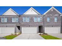 New townhomes boast brick exteriors, attached garages, and manicured lawns at 240 Epping Dr, Stockbridge, GA 30281