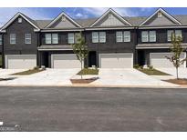New townhome construction showcasing brick facades, attached garages, and manicured lawns at 240 Epping Drive, Stockbridge, GA 30281