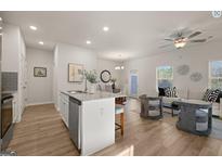 Bright, open-concept living area featuring hardwood floors, modern furnishings, and a seamless flow to the kitchen at 256 Epping Drive, Stockbridge, GA 30281