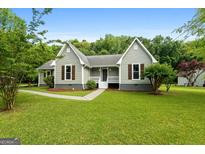 Charming single-story home featuring a well-maintained lawn, complemented by mature trees and classic shutters at 106 June Ct, Hampton, GA 30228