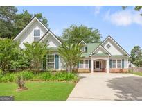 Charming home with a lush green lawn, mature trees, and a long driveway at 2340 Landrum Ct, Lawrenceville, GA 30043
