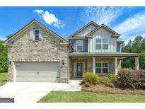 Charming two-story home featuring a brick facade, covered porch, and well-maintained landscaping at 5016 Brass Ct # 195, Locust Grove, GA 30248