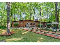 Charming brick ranch-style home with well-manicured lawn and inviting front entrance surrounded by lush landscaping and mature trees at 1813 Freeman Rd, Jonesboro, GA 30236