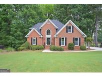 Charming brick home with a well-manicured lawn and mature trees offering great curb appeal at 5028 Chapel Lake Cir, Douglasville, GA 30135