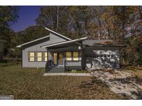 Charming modern home with gray siding, covered porch, and attached garage, perfect for comfortable living at 7428 Mockingbird Trl, Riverdale, GA 30274
