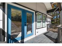Inviting porch with blue double doors and black trim creating a modern and stylish entryway at 7428 Mockingbird Trl, Riverdale, GA 30274
