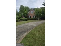 Charming brick home with a well-manicured lawn and a curved driveway at 2329 Lochinver Sw Ln, Conyers, GA 30094