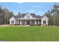 Inviting two-story modern farmhouse with black accents, a front porch, and a lush green lawn at 3911 Peeksville Rd, Locust Grove, GA 30248