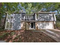 Charming two-story home with a stone accent, attached garage and professionally landscaped front yard at 5362 Kelleys Mill Cir, Stone Mountain, GA 30088