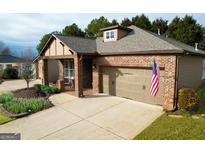Charming single-story brick home featuring an attached two-car garage and an inviting covered front porch at 511 Bonneset Ct, Canton, GA 30114