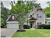 Inviting home featuring a lush green lawn, mature trees, and a two-car garage at 330 Bentleigh Station Dr, Acworth, GA 30101