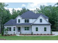 Two-story home with a stone facade, white siding, gray shutters, and well-manicured landscaping at 214 Wet Wood Ct # 26, Fairburn, GA 30213