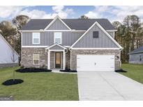 New construction two-story home featuring a brick and gray exterior, manicured lawn, and an attached two-car garage at 3402 Arabian Farm Ln, Dacula, GA 30019