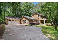 Inviting two-story home with a spacious driveway and attached two-car garage, set amidst lush greenery at 2201 Valley Creek Cir, Snellville, GA 30078