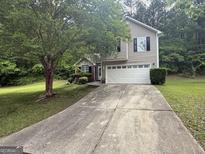 Charming two-story home with a two-car garage and well-maintained lawn at 7090 E Village Ct, Riverdale, GA 30296