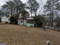 Charming single-story home with a welcoming screened front porch and a yard covered in fallen leaves at 2010 Mcafee Pl, Decatur, GA 30032