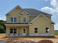 New two-story home with tan siding, white trim, black roof, and unfinished front yard at 252 Old Jackson Rd, Mcdonough, GA 30252