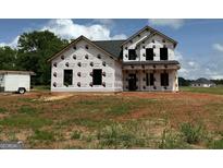 New two-story home under construction with protective wrap in a spacious, open lot at 1916 King Mill Rd, Mcdonough, GA 30252