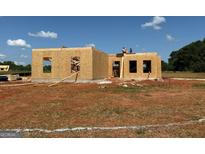 New home is under construction with wood framing and a blue sky on a large lot at 1916 King Mill Rd, Mcdonough, GA 30252