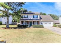 Charming two-story home with a manicured lawn and inviting curb appeal on a sunny day at 421 Old Ivy Path, Mcdonough, GA 30253
