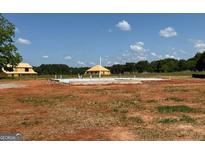 New home construction site with concrete foundation and wood framing under a blue sky at 1936 King Mill Rd, Mcdonough, GA 30252