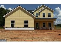 New construction featuring yellow siding, black roof, white trim, and bright windows at 1936 King Mill Rd, Mcdonough, GA 30252