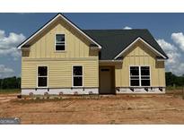 New construction home with yellow siding and a black roof, exuding modern charm at 1926 King Mill Rd, Mcdonough, GA 30252