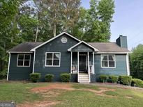 Charming single-story home featuring a cozy front porch and well-maintained landscaping at 150 Doe Run Ct, Sharpsburg, GA 30277