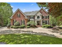 Stately brick home with mature landscaping, circular driveway, and traditional architectural details at 106 Hidden Springs Ln, Peachtree City, GA 30269